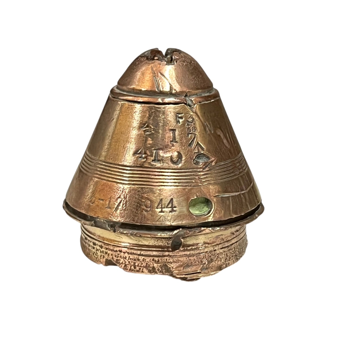 WW1 brass fuse paperweight with markings from use on a white background