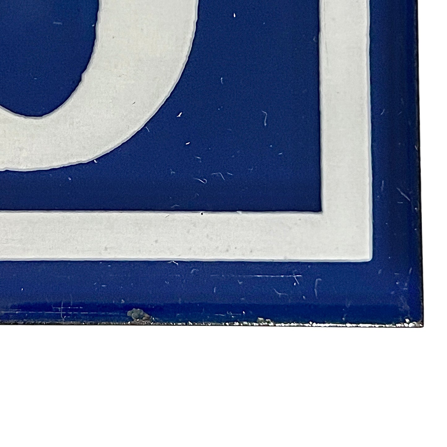 Close up of a French blue and white enamel door number - bottom right corner