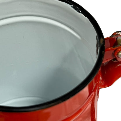 Close up of a red vintage French enamelled coffee pot on a white background