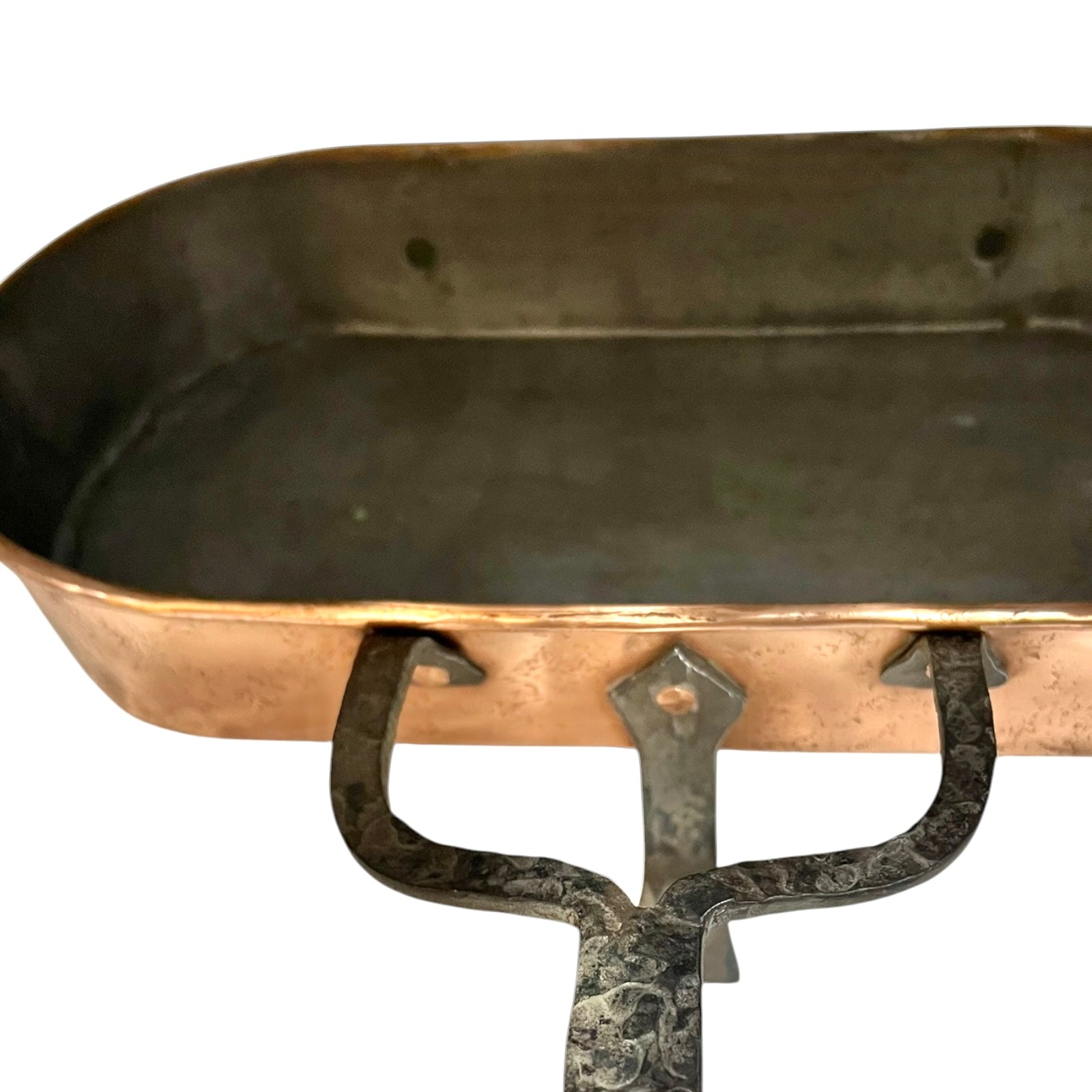 Close up of a copper roasting pan with a long handle on a white background
