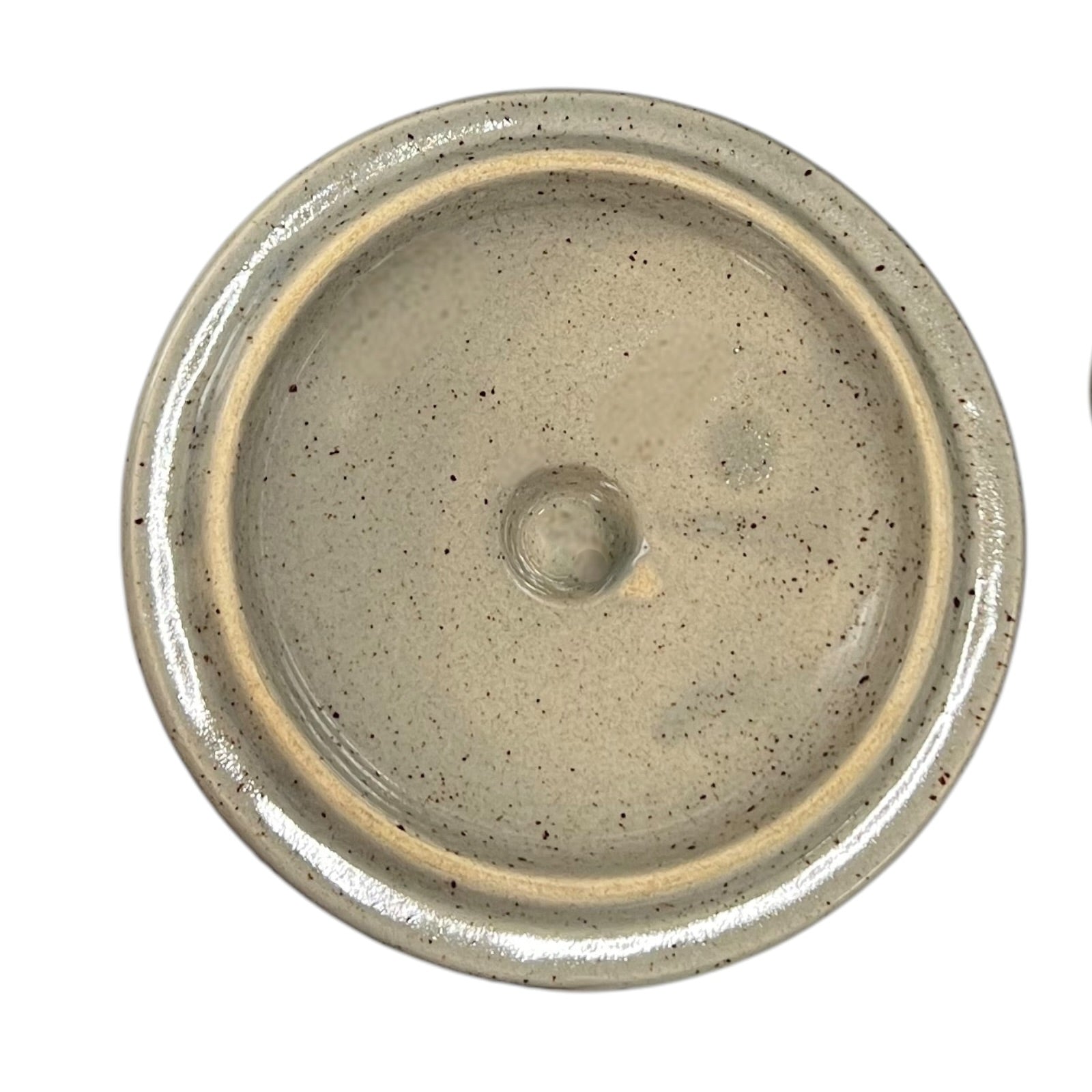 Close up of a speckled ceramic container on a white background