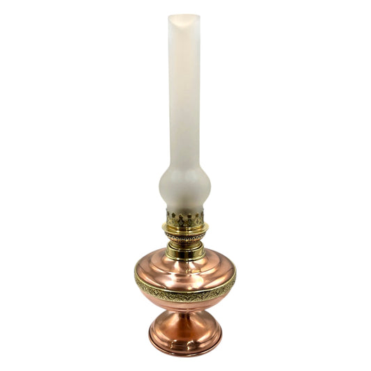 Decorative copper and brass oil lamp with a frosted chimney on a white background