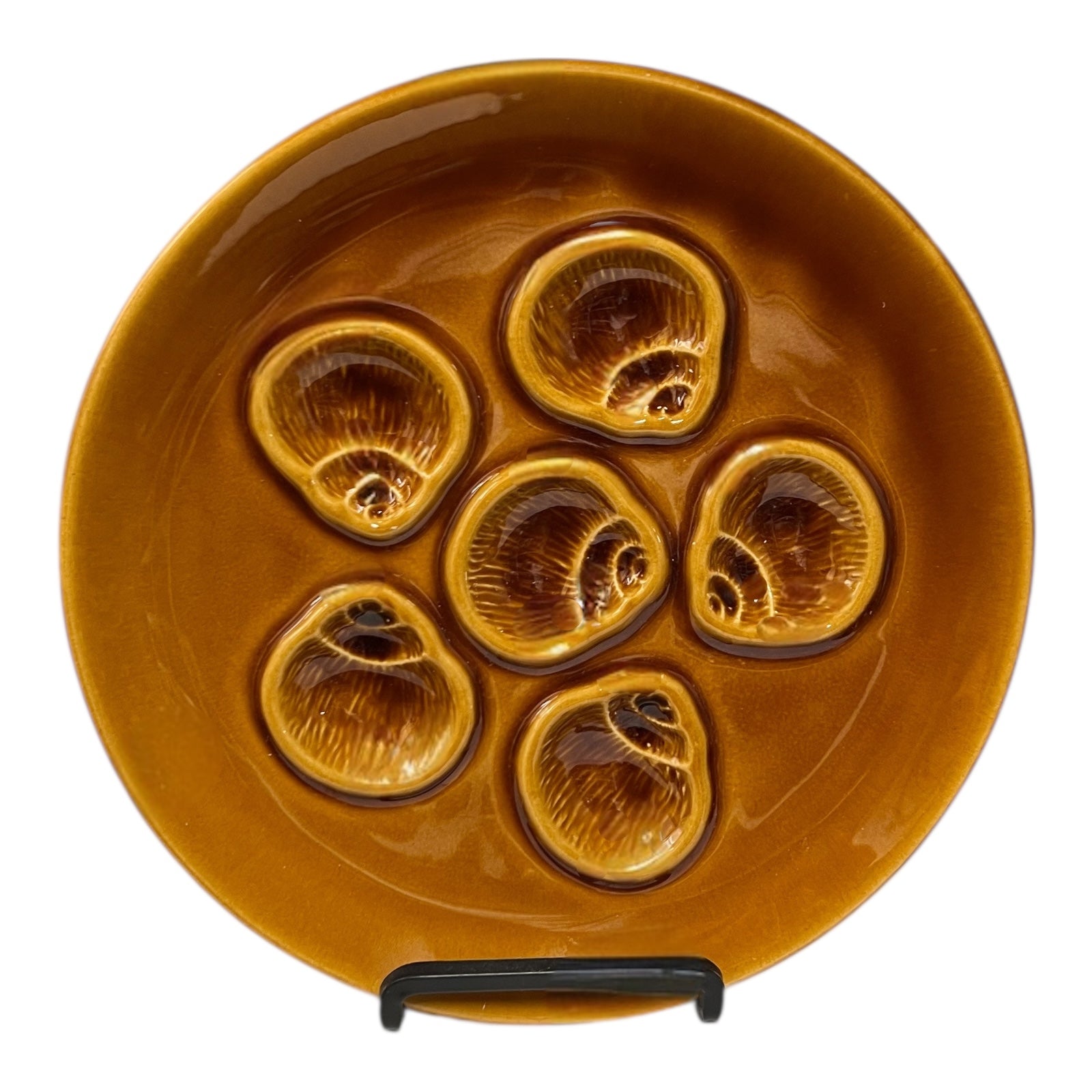 Brown ceramic plate with six circular depressions on a white background