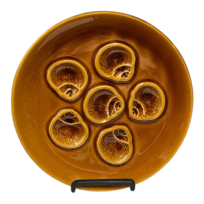 Brown ceramic plate with six circular depressions on a white background