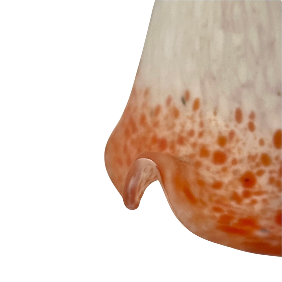 A close-up of a curved, glossy surface with a warm peachy-orange speckled pattern concentrated along the lower half, set against a plain white background.