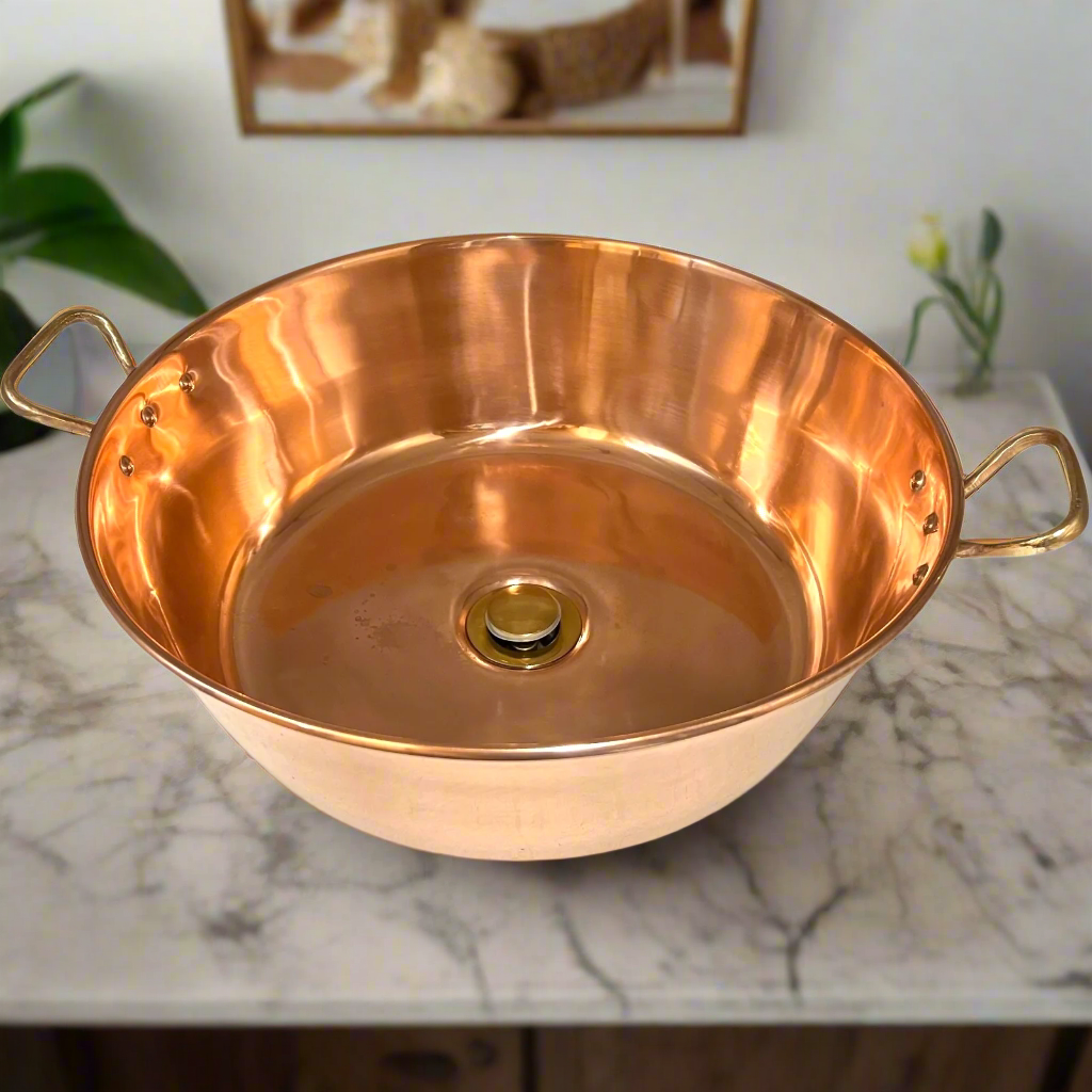 Copper bathroom sink basin with brass handles and a brass waste handles on a marble surface for sale from All Things French Sore