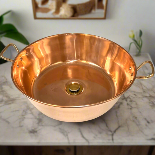 Copper bathroom sink basin with brass handles and a brass waste handles on a marble surface for sale from All Things French Sore