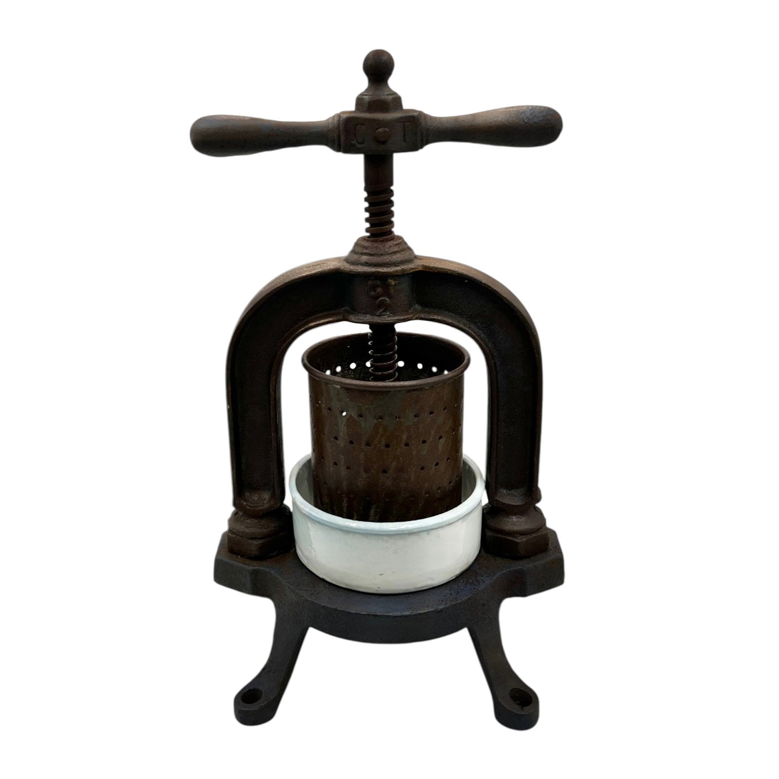 Vintage French cast iron metal fruit press with a white enamel container on a white background