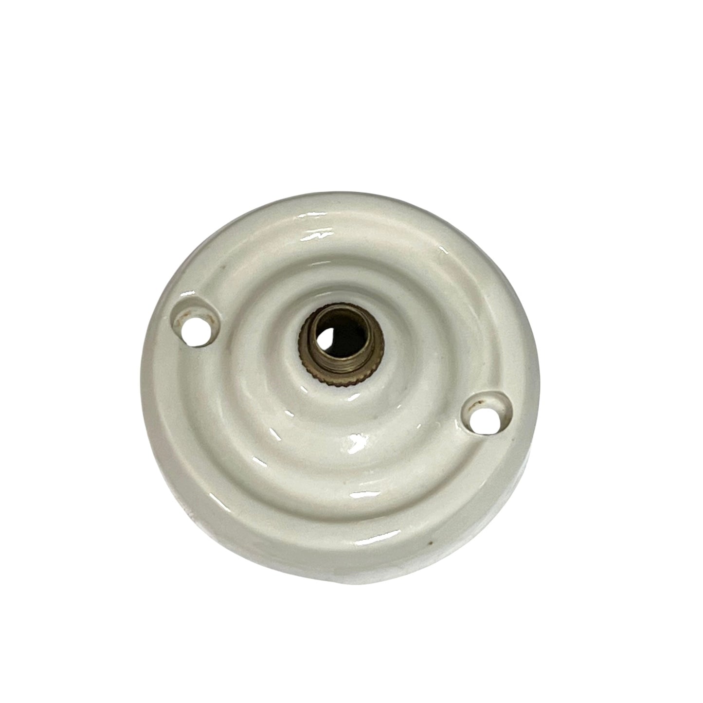 A vintage white porcelain ceiling rose with a brass screw connector on top, isolated on a white background.