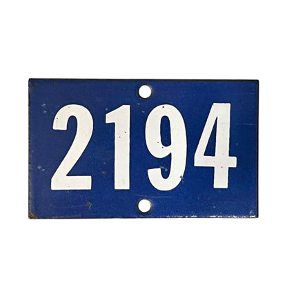 A rectangular blue metal house number plaque with the white numbers '2194' and two mounting holes, shown against a plain white background.