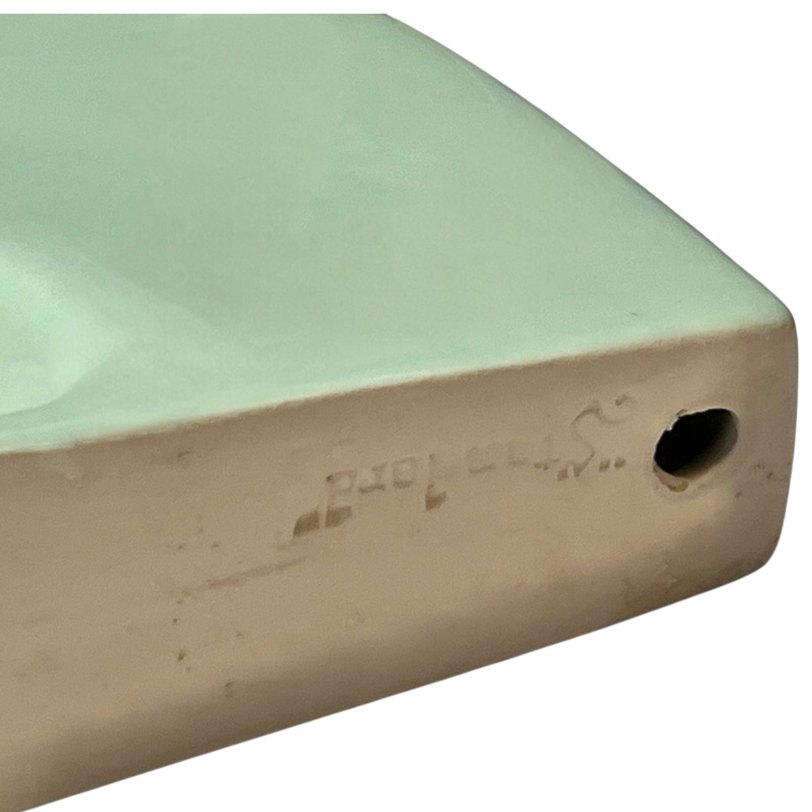 back view of pale green ceramic shelf on a white background