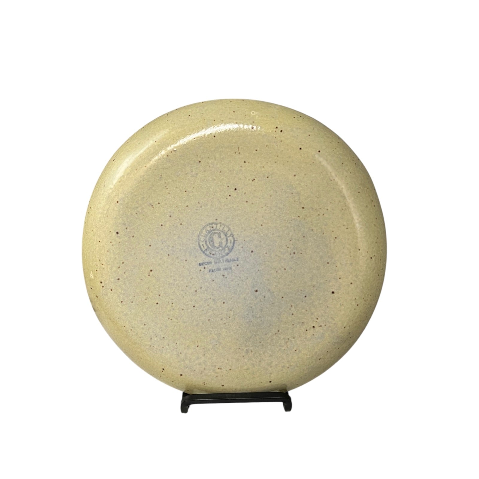 Beige plate on a stand with a visible brand logo against a white background