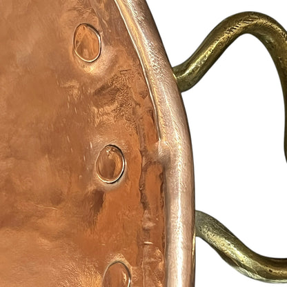 Close-up of a textured metal object with a gold handle on a white background