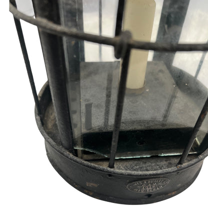 Close-up of a black metal lantern with glass panels on a white background