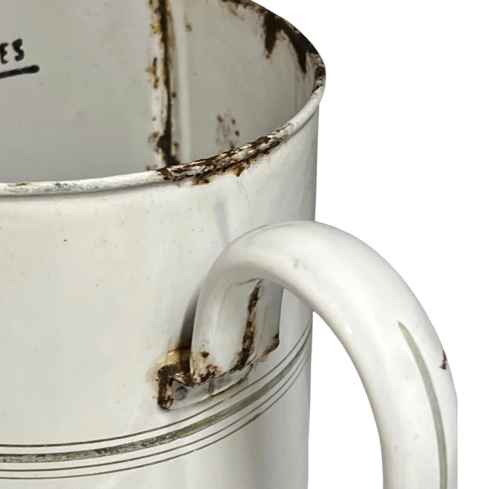 A close-up of a vintage white enamel pitcher with a curved handle, showing weathered rusted detailing along the rim and handle joint, on a white background.