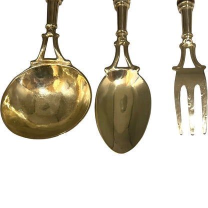 Set of gold-colored spoons and a fork on a white background