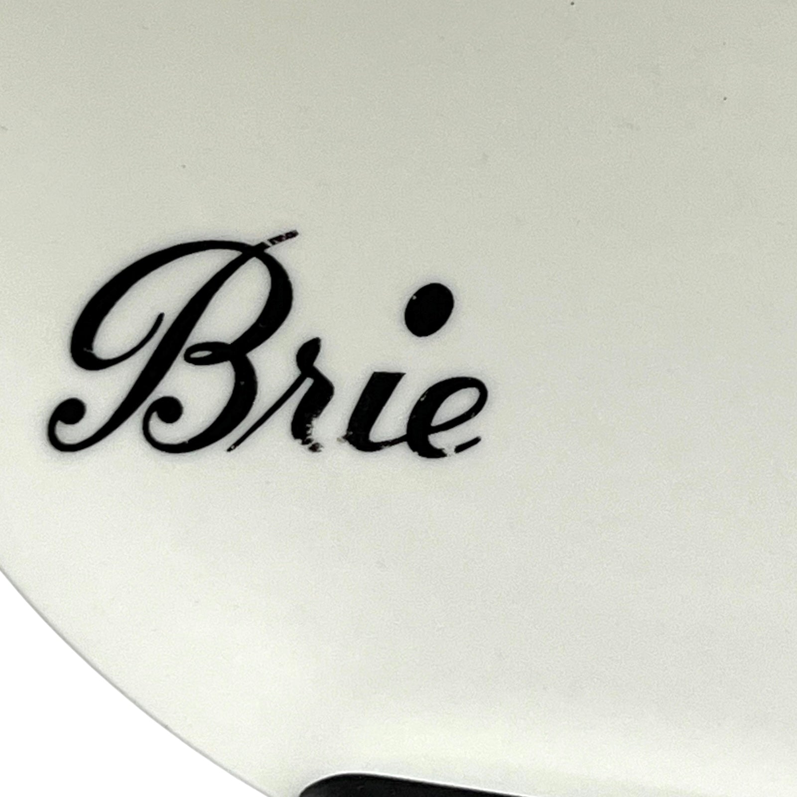 White cheese plate with 'Brie' text in black on a white background