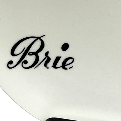 White cheese plate with 'Brie' text in black on a white background