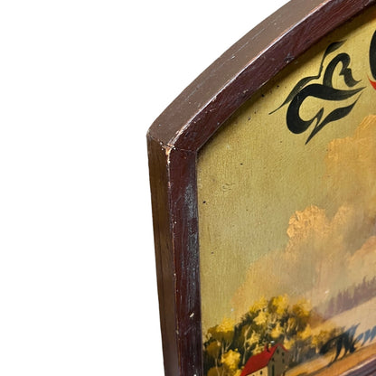 Close-up of an antique style landscape painting in a wooden frame, showing a yellow sky, trees, and a house, with a white background.