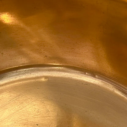 Close-up of a copper sink with a drain plug on a white background
