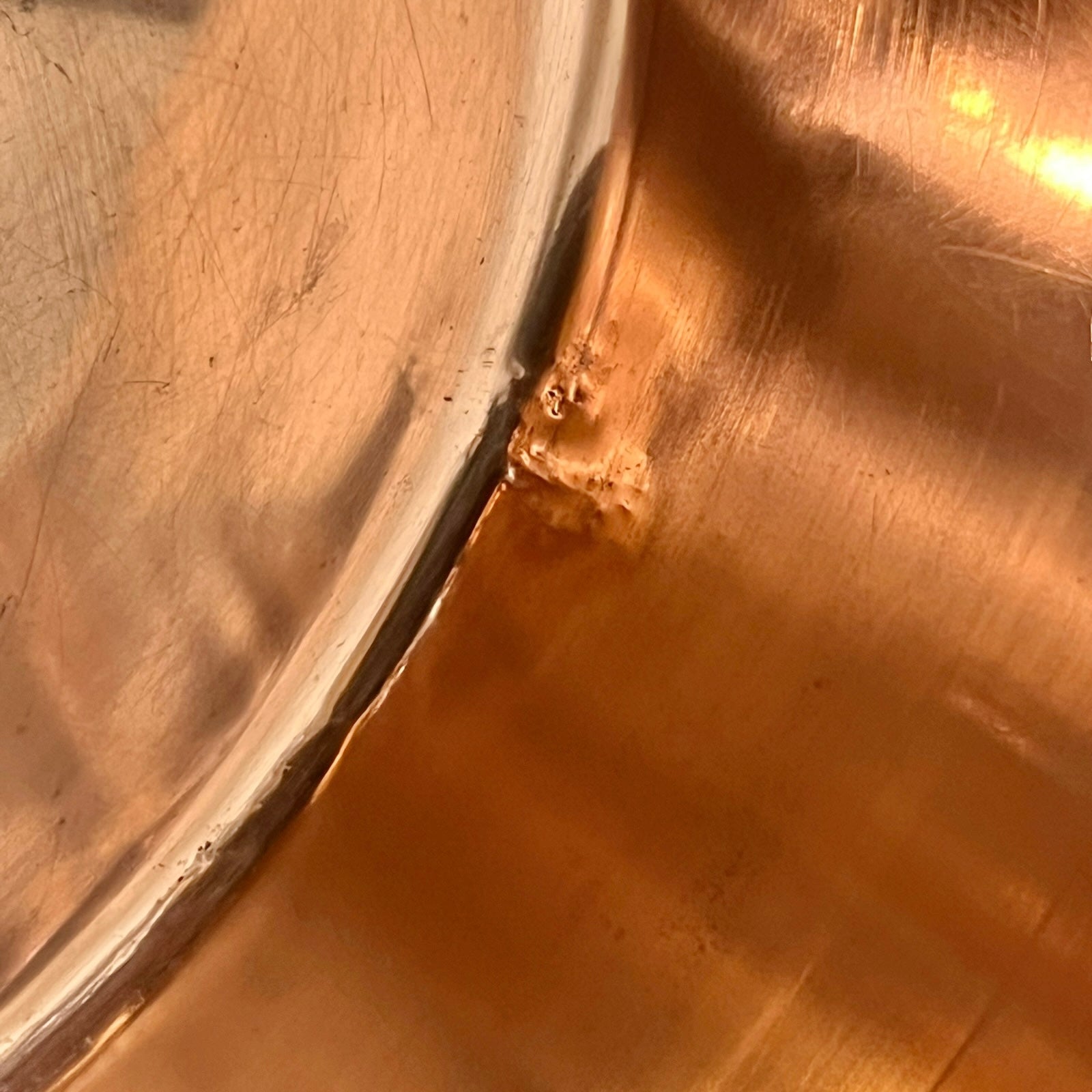 Close-up of a copper sink with a drain plug