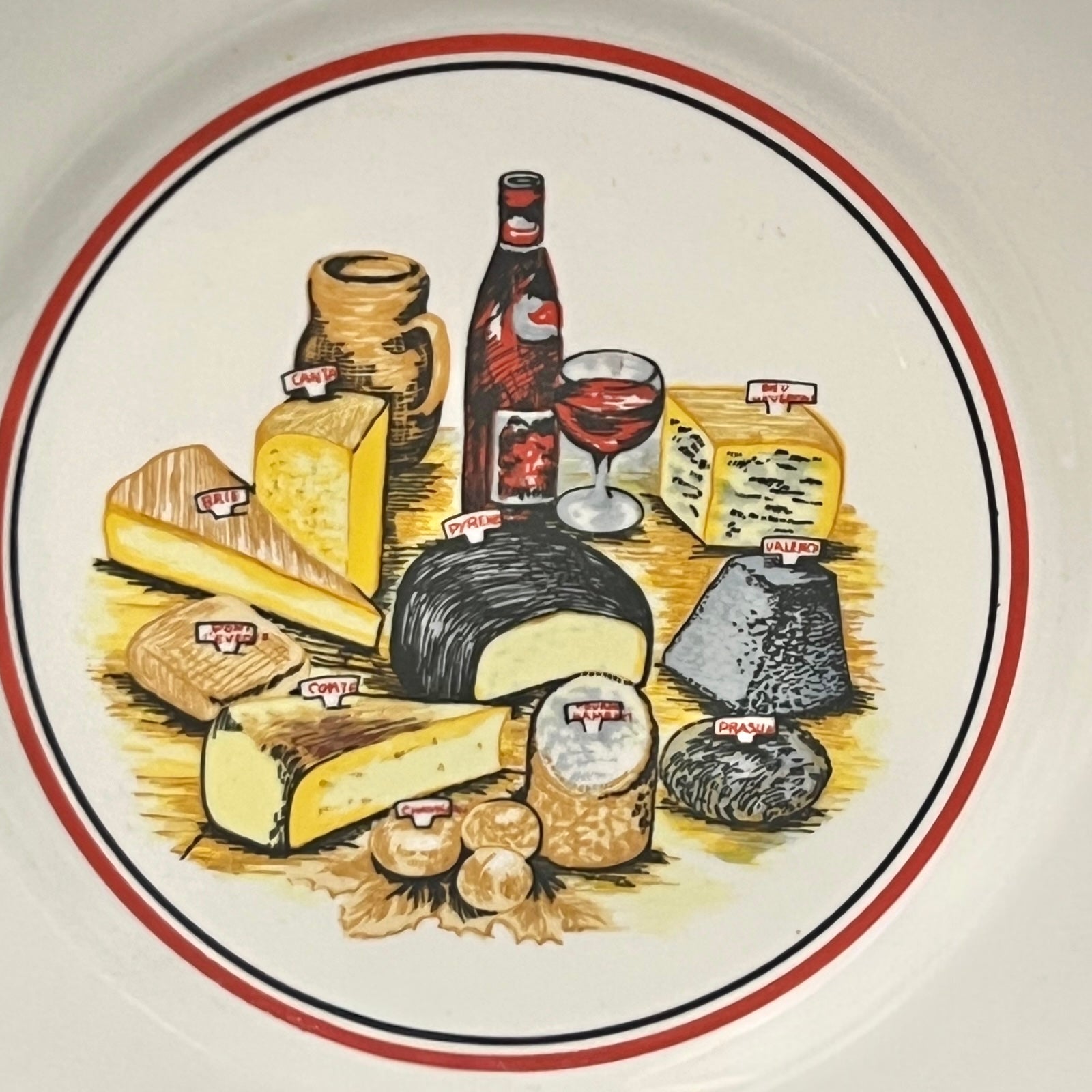 Decorative plate with illustrations of cheeses, a bottle, and a glass on a white background.