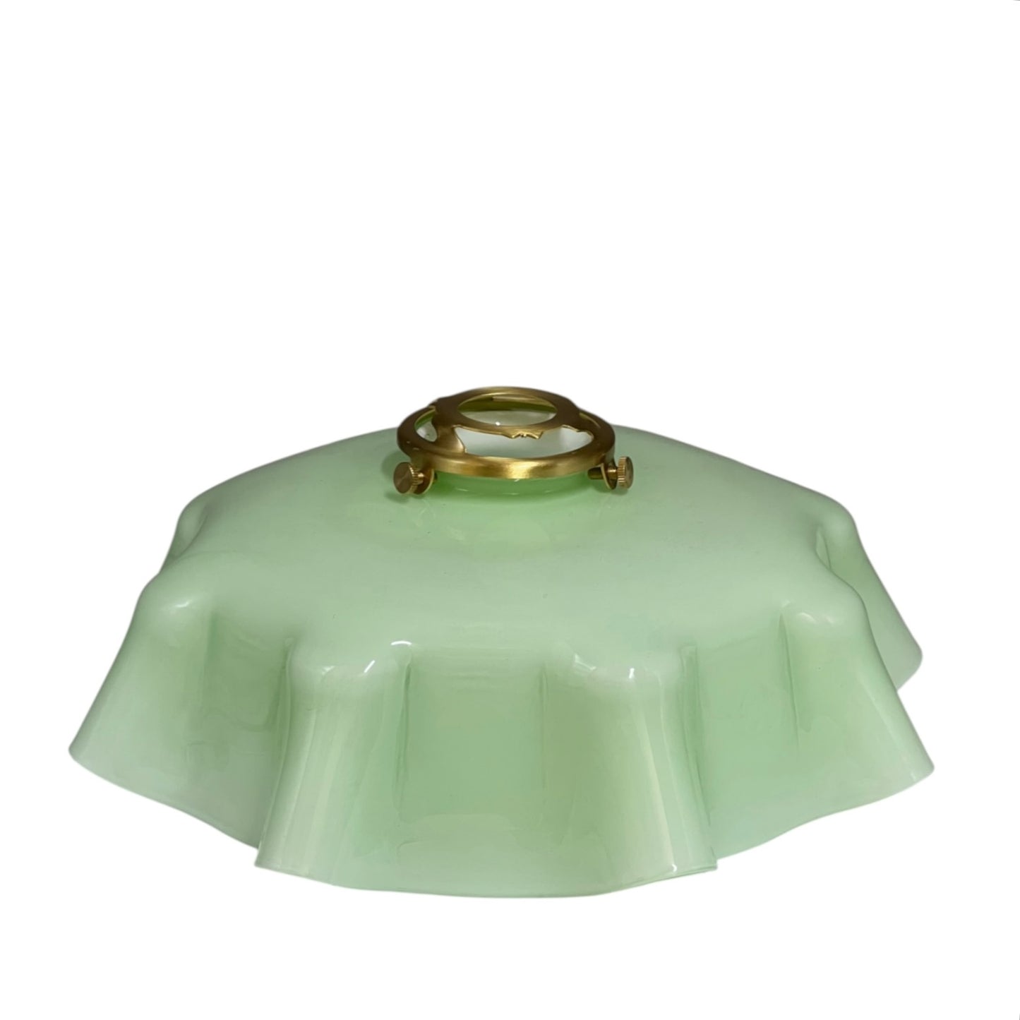 pale green milk glass lampshade with brass fittings on a white background