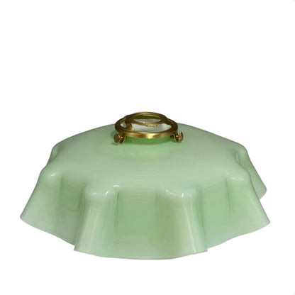 pale green milk glass lampshade with brass fittings on a white background