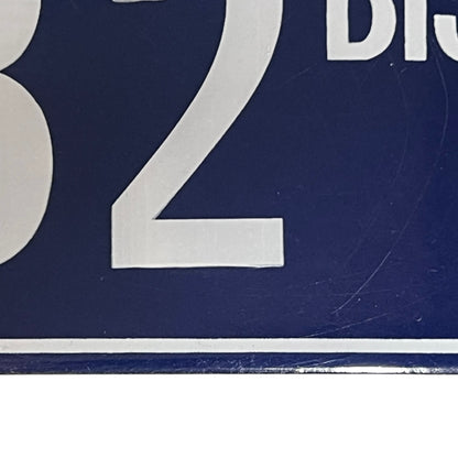 Close up of a French enamel door number 32 on a white background 