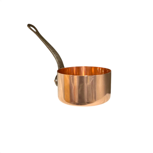Copper saucepan with a black cast iron handle on a white background