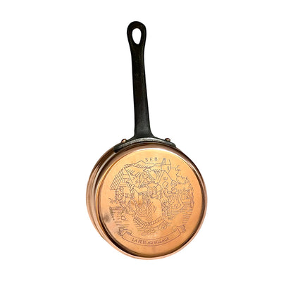 Small copper saucepan with an engraved pattern and a black handle on a white background