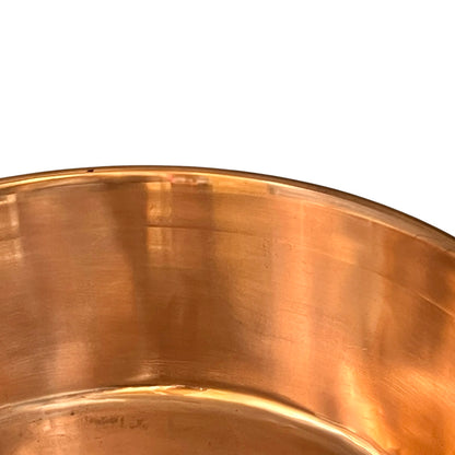 Close-up of a copper sink with a drain plug