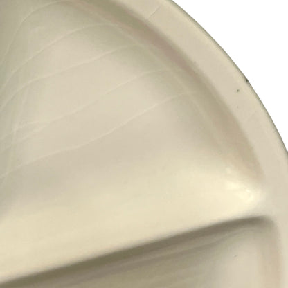 Close-up of a beige ceramic plate with a textured surface.
