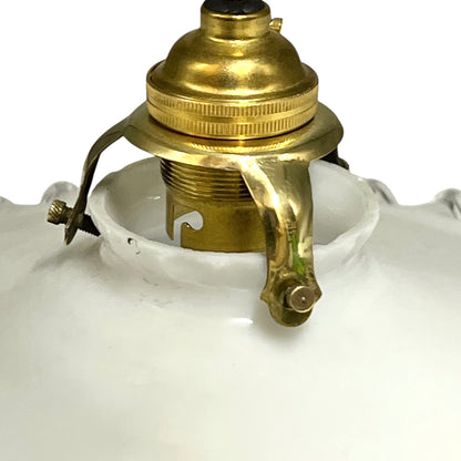 Close-up of a white glass lamp shade with a brass metal socket and hanger assembly visible at the top, on a white background.