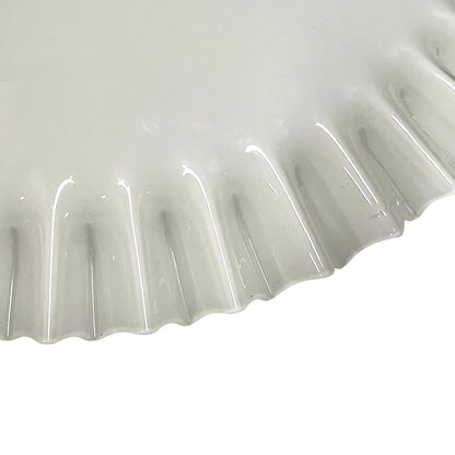 Close-up of a ribbed white glass lampshade on a white background