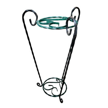 Green and black wrought iron jardinière scrolled plant stand on a white background