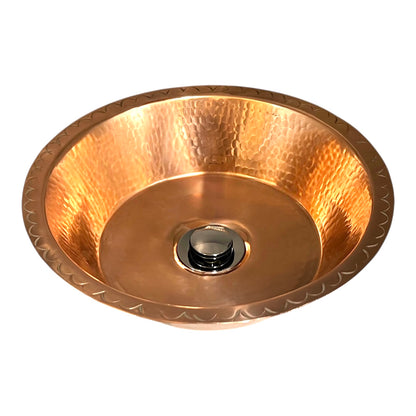 Copper sink with embossed design on a white background