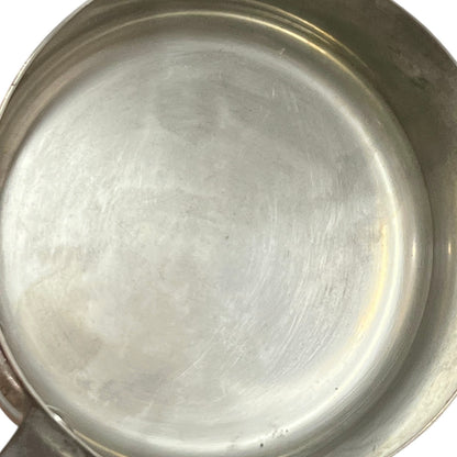 Close-up of copper cookware with iron handles on a white background