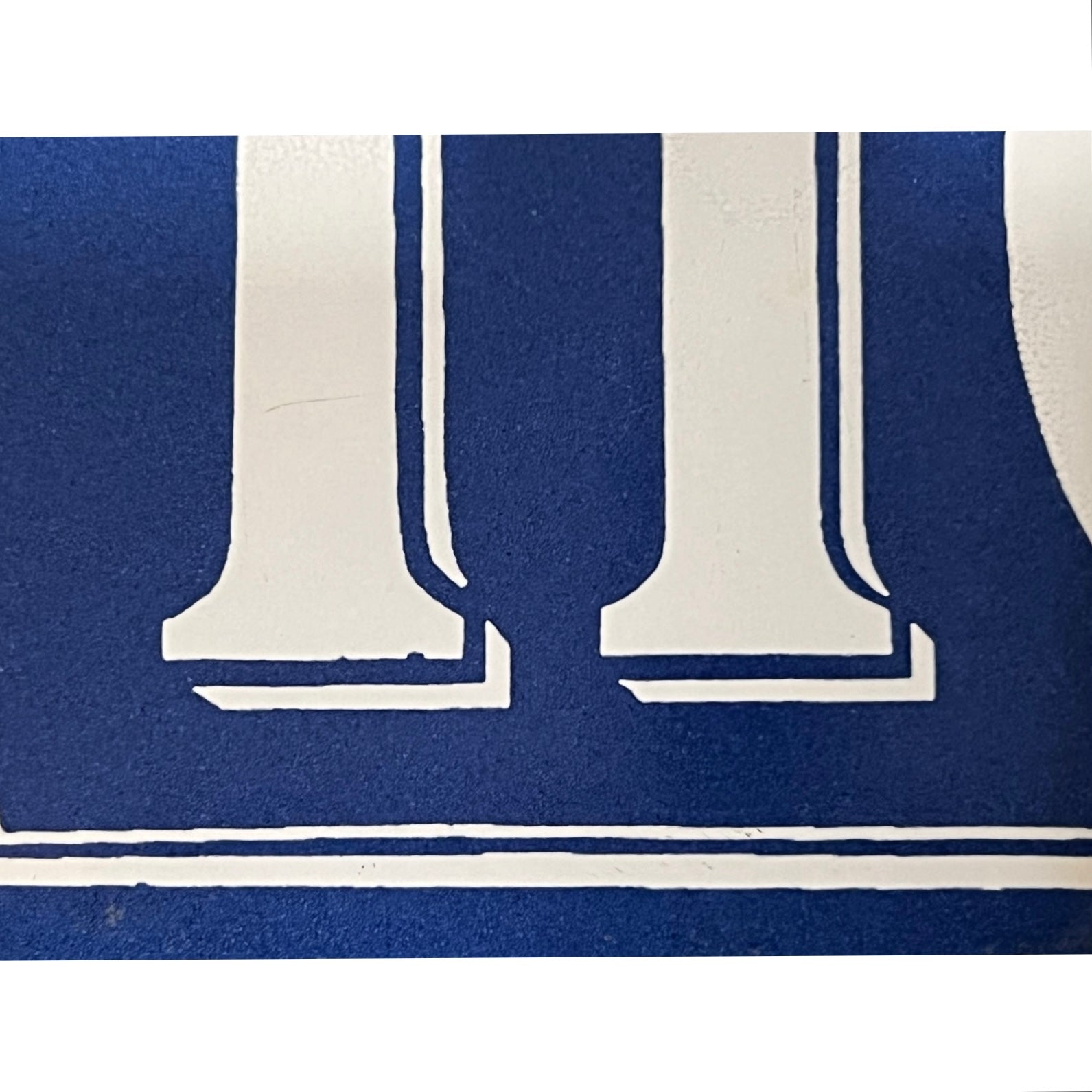 Close-up of a blue sign with a white numbers on a white background