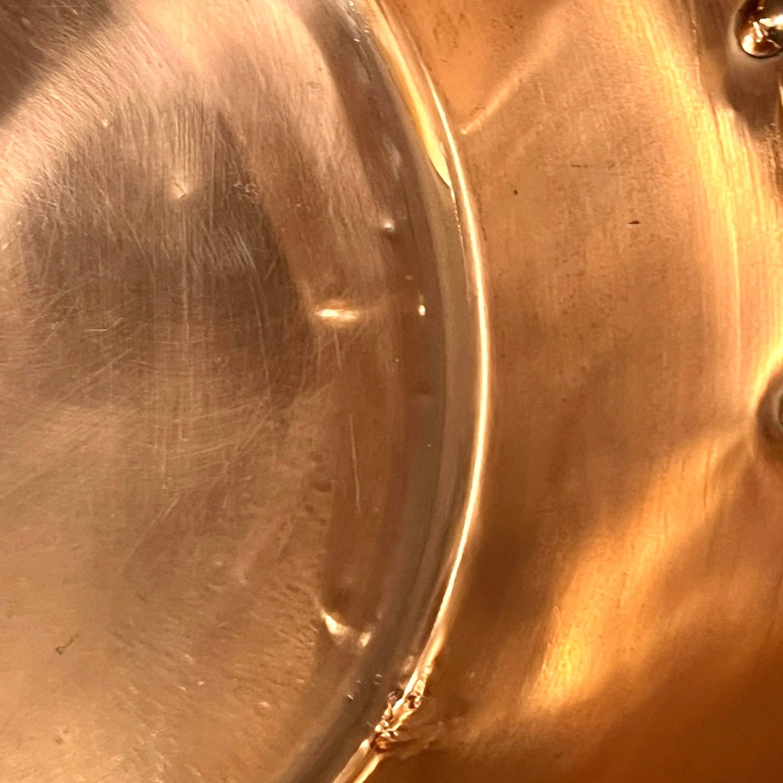 Close-up of a copper sink with a drain plug