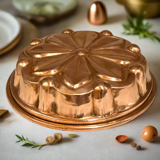 Vintage French round copper cake tin or jelly mold with decorative design on a table with ingredients for sale from All Things French Store