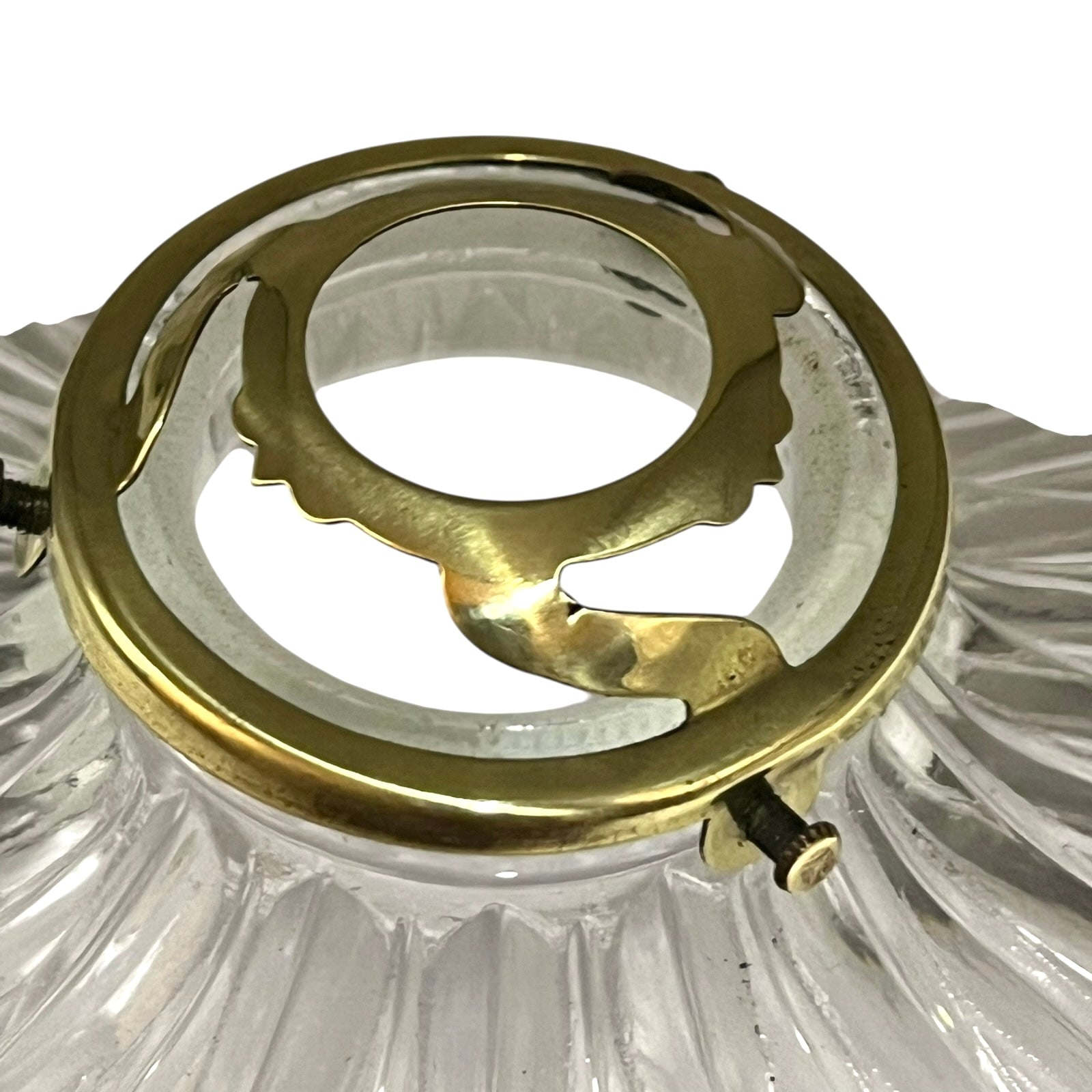 Close-up of a brass fitting inside a clear glass light fixture on a white background