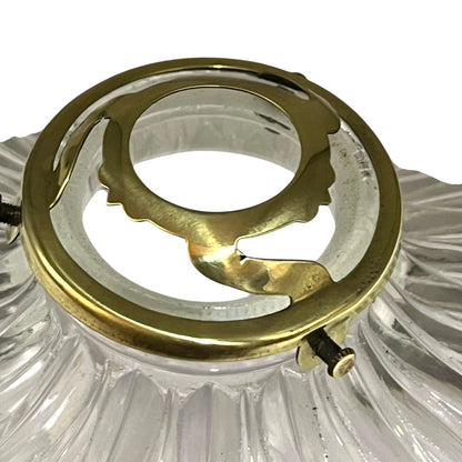 Close-up of a brass fitting inside a clear glass light fixture on a white background