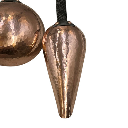 Close up of French copper kitchen utensils with black handles on a white background