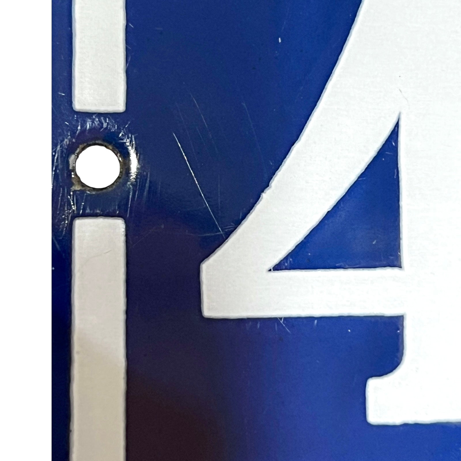 detailed view of a vintage French enamel door number against a white background.