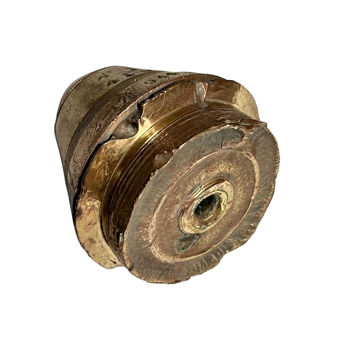 WW1 brass fuse paperweight with markings from use on a white background