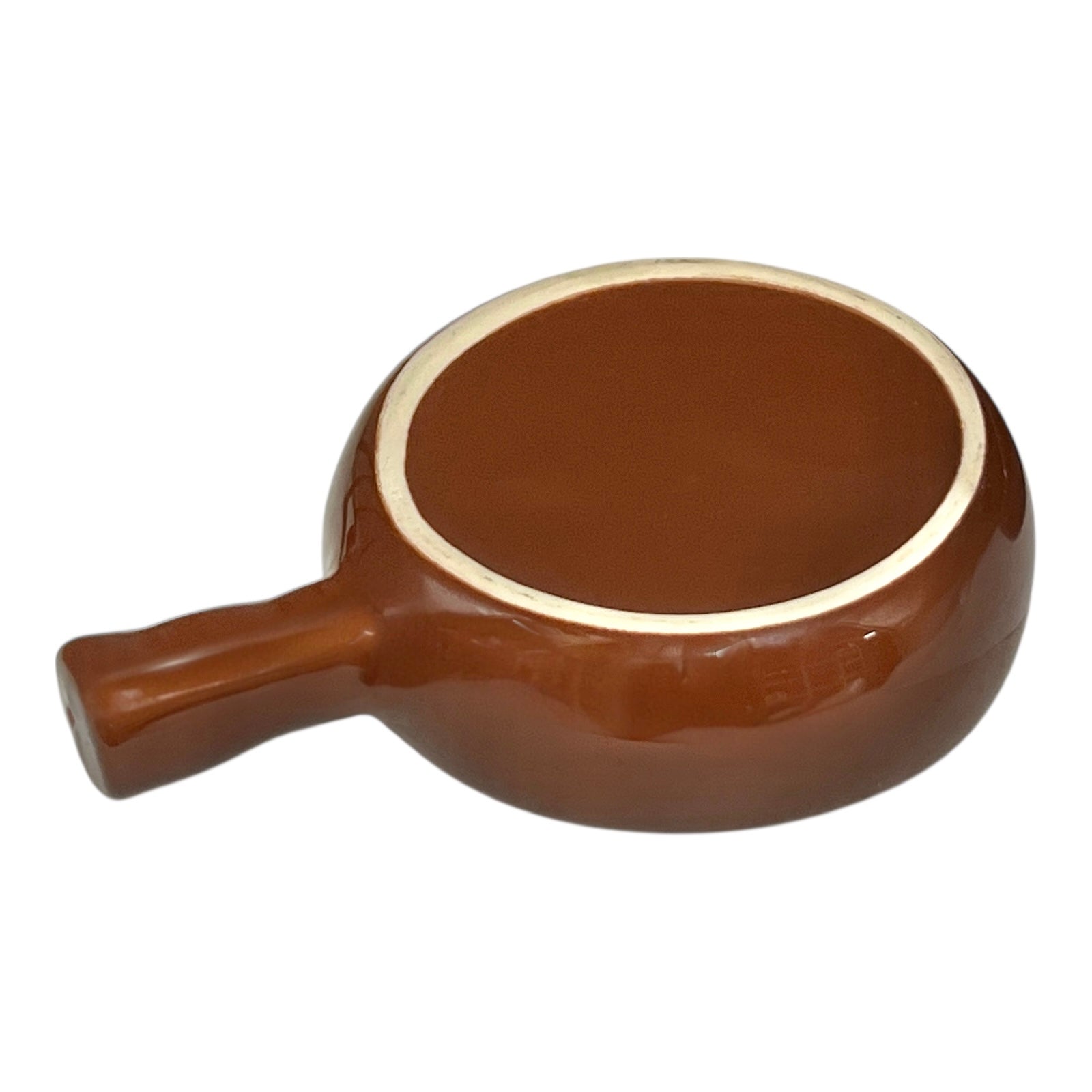 close up underside view of brown ceramic escargots dish with handles and a pale interior, on a white background.