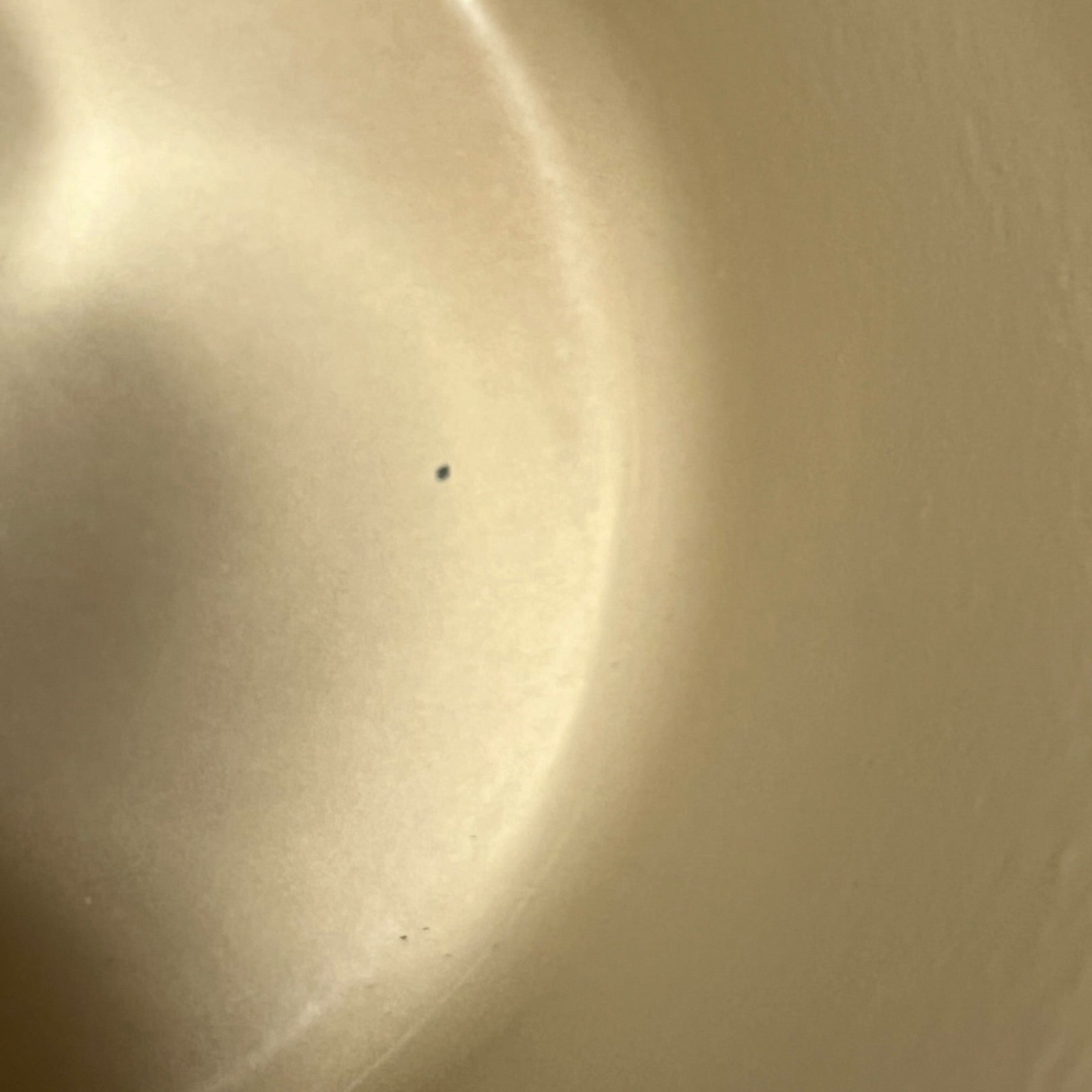 Close up of a rust coloured cast iron saucepan with lid on a white background