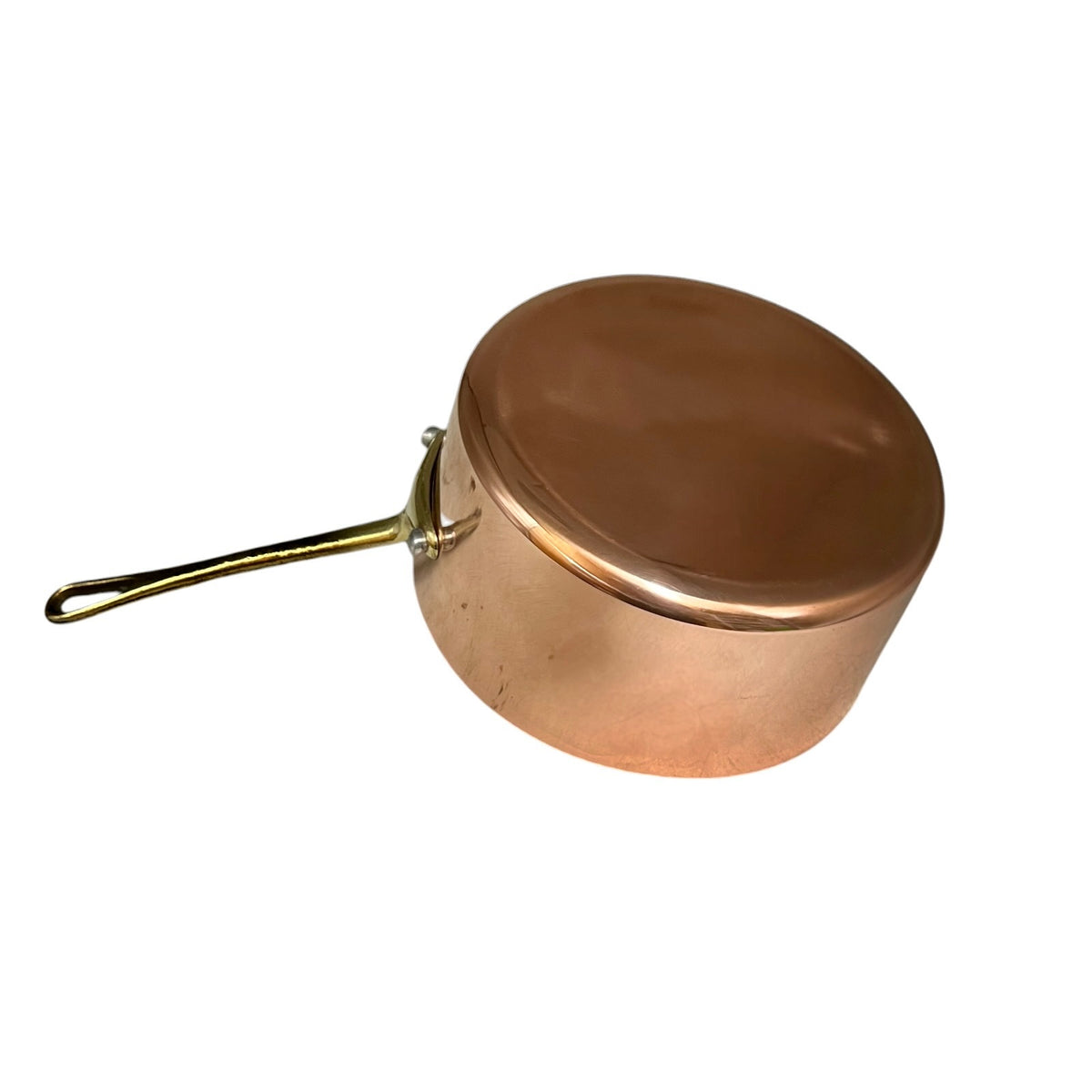 A copper saucepan with a lid and a long brass handle, shown from an elevated angle on a plain white background.