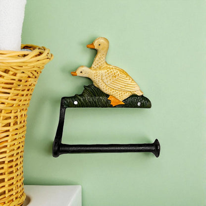 French farmhouse style goose cast iron toilet roll holder on a green wall with a bathroom in the  background
